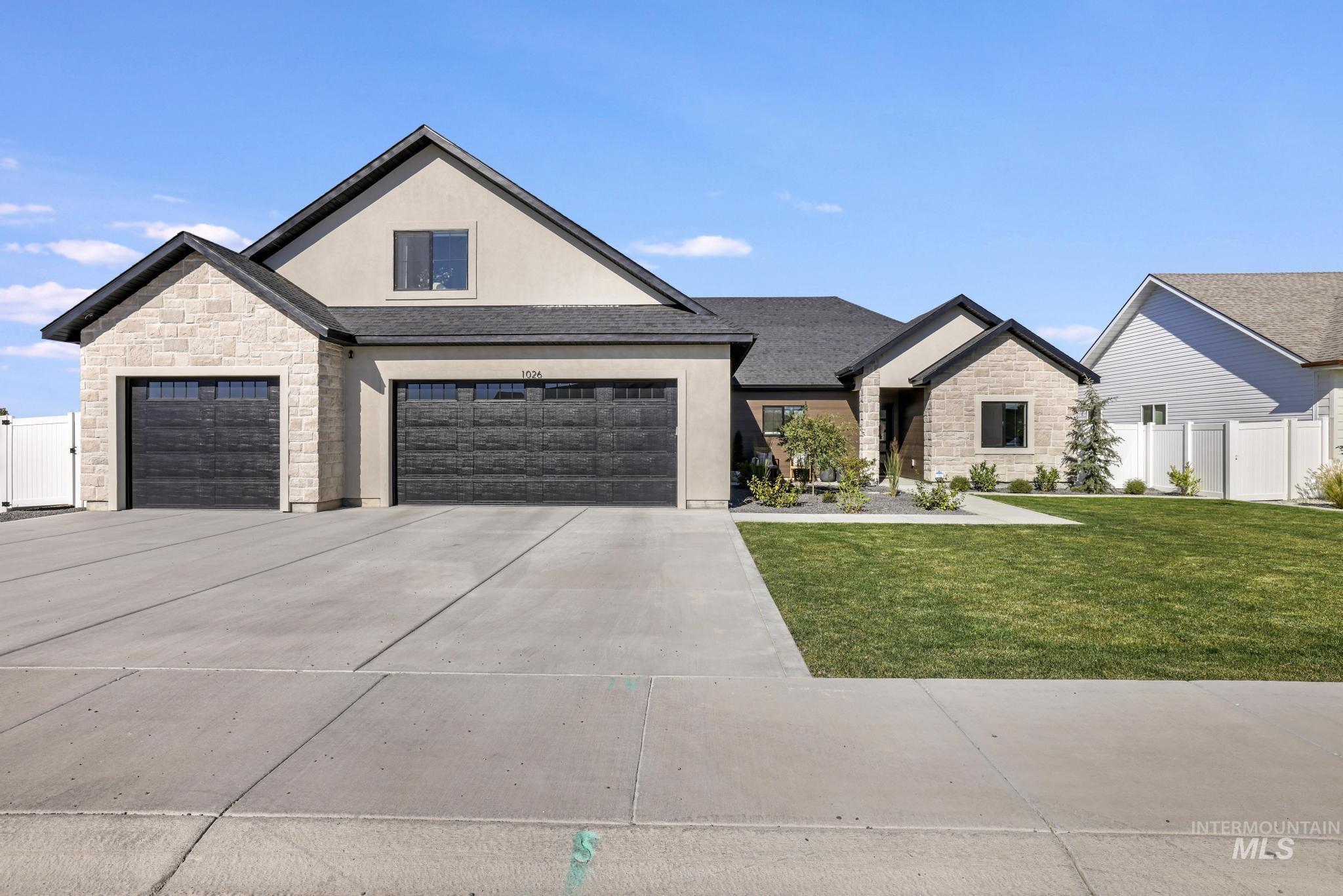 View of front of home with stone siding, stucco siding, concrete driveway, and a shingled roof