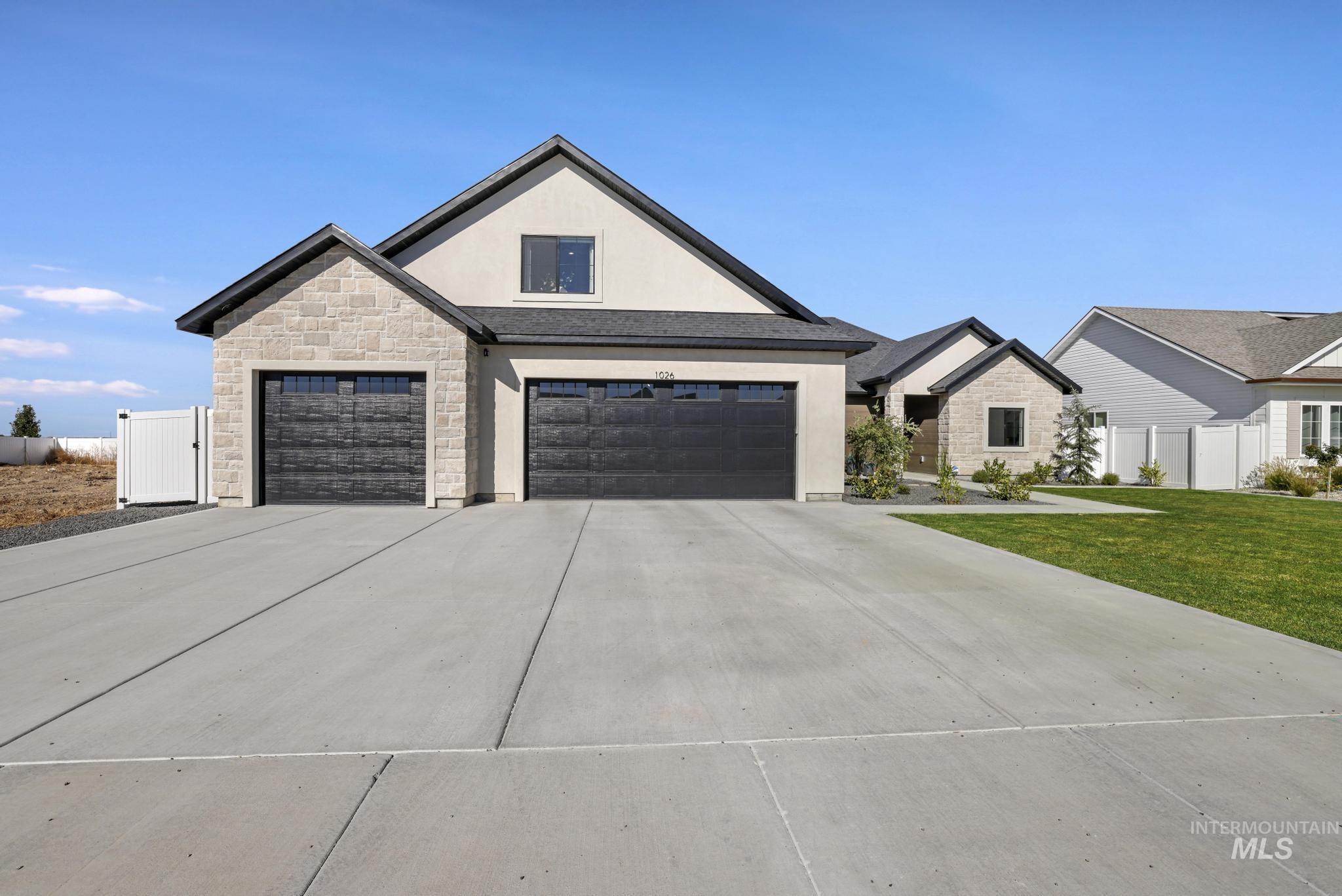 View of front of property featuring stone siding, stucco siding, concrete driveway, and a garage