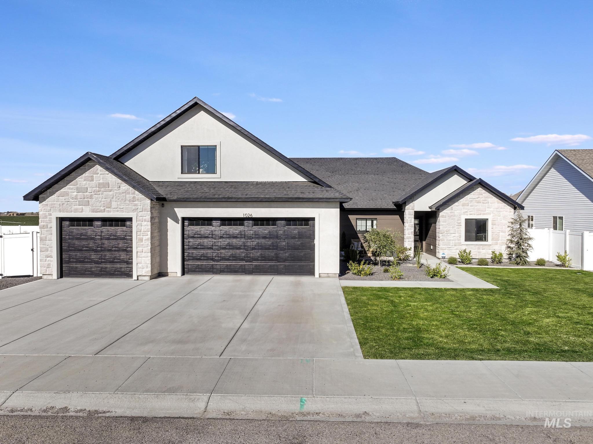 View of front of property with stone siding, stucco siding, concrete driveway, and roof with shingles