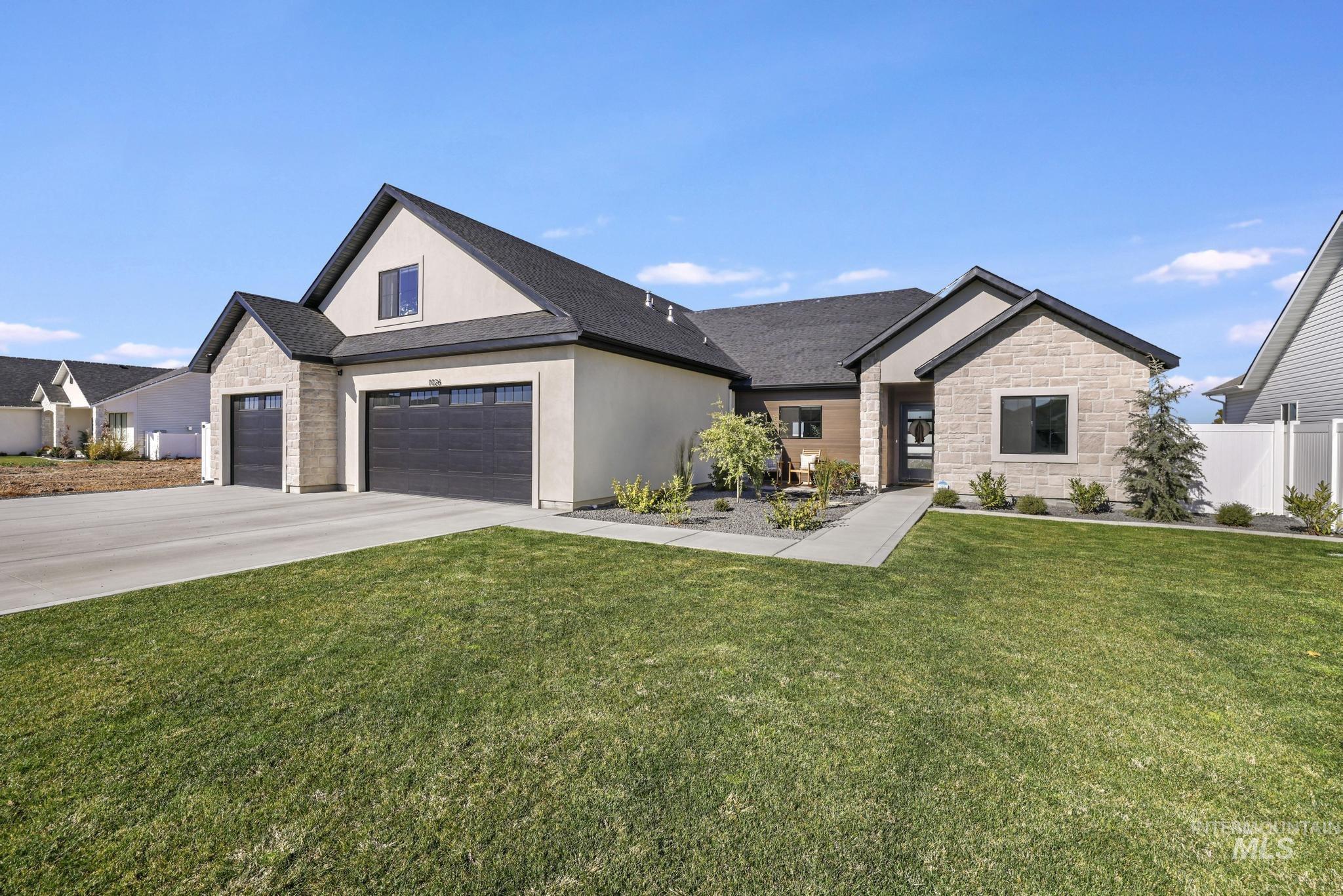 Modern inspired farmhouse featuring stone siding, driveway, and stucco siding