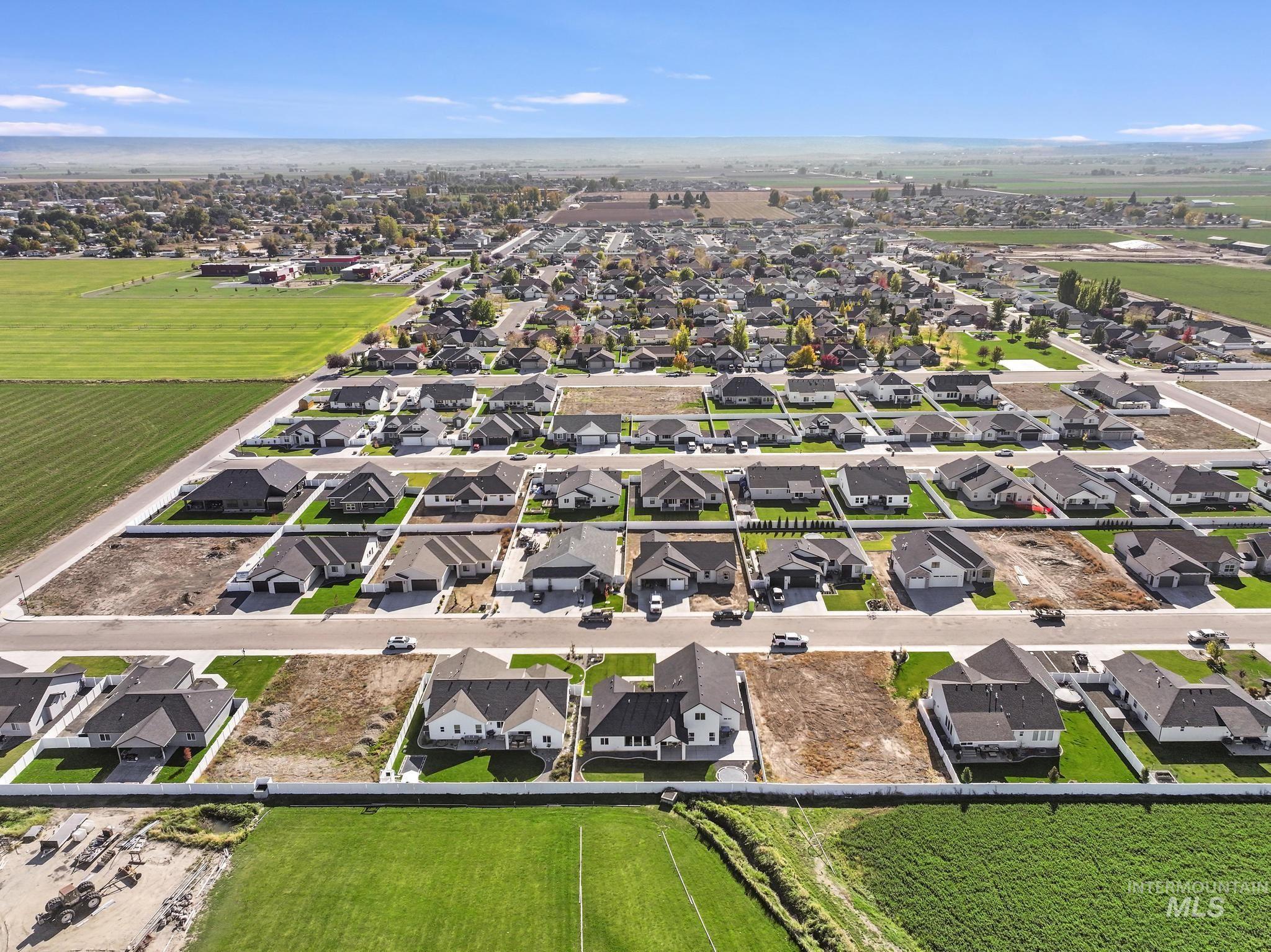 Aerial view of property and surrounding area with nearby suburban area