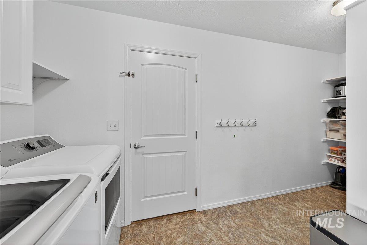 Laundry area featuring a textured ceiling and washer and clothes dryer