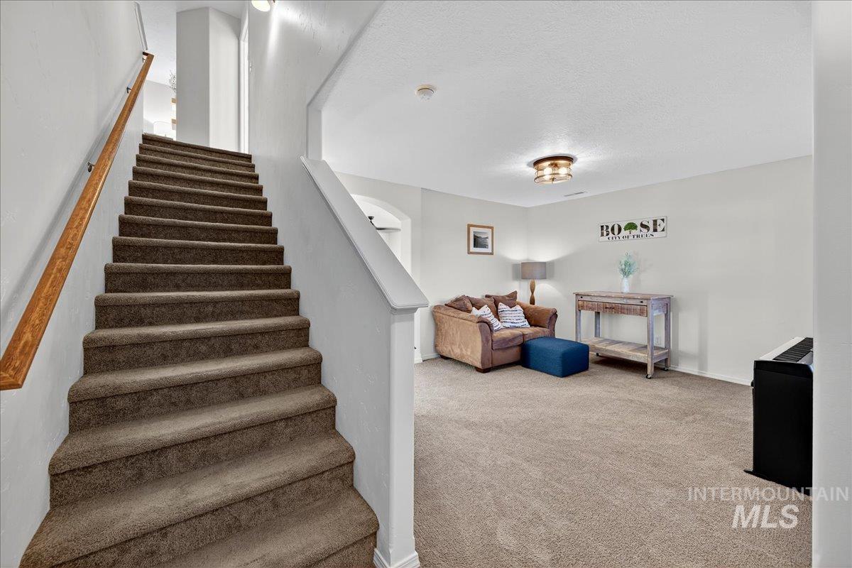 Staircase with a textured ceiling and carpet flooring