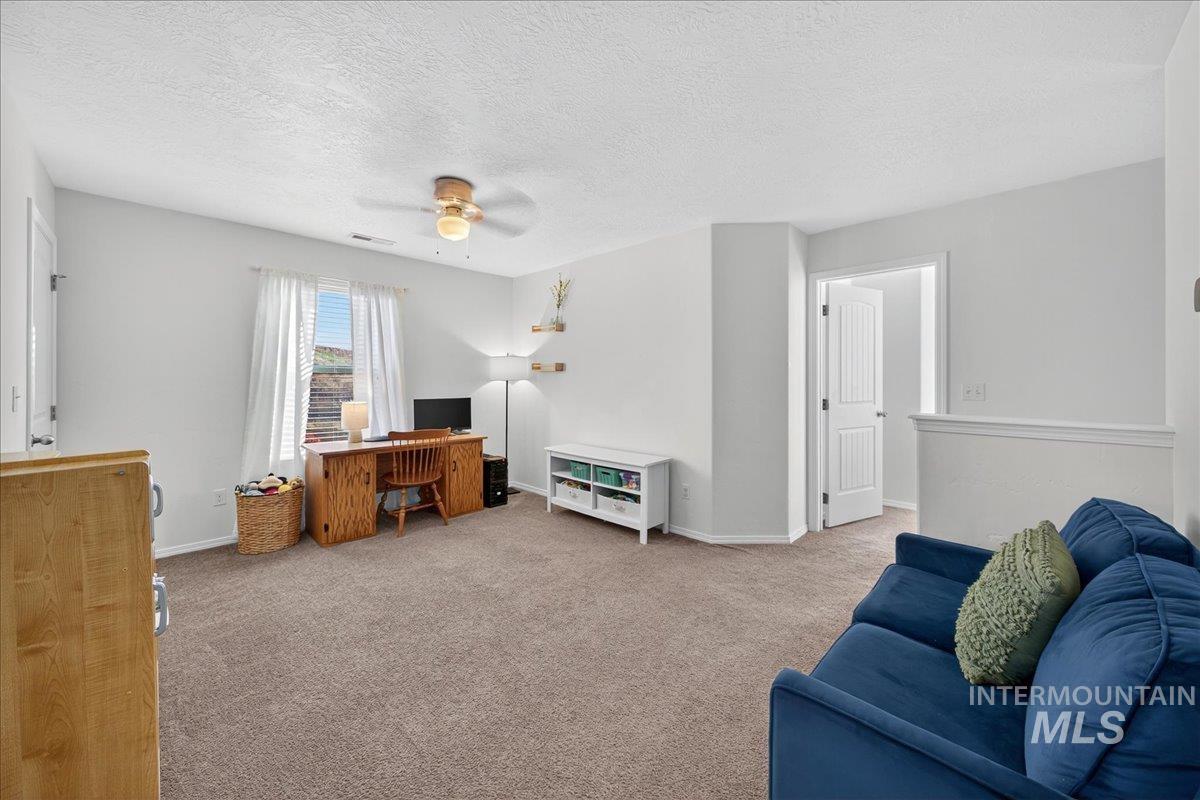 Office area featuring carpet, a textured ceiling, and ceiling fan