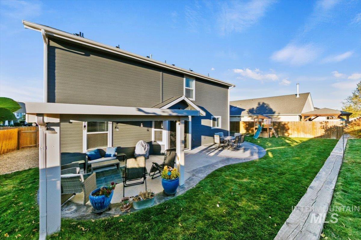 Rear view of property featuring a fenced backyard, outdoor lounge area, a patio, and a playground