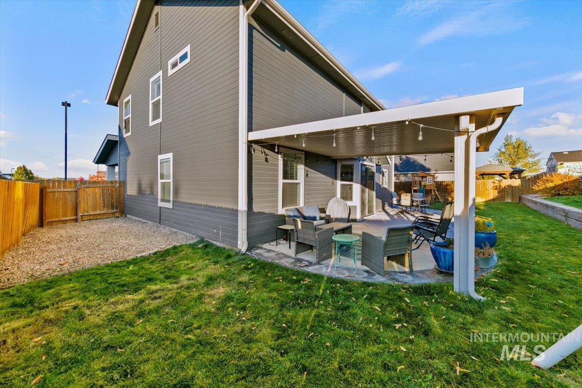 Back of property with a fenced backyard, outdoor lounge area, and a patio