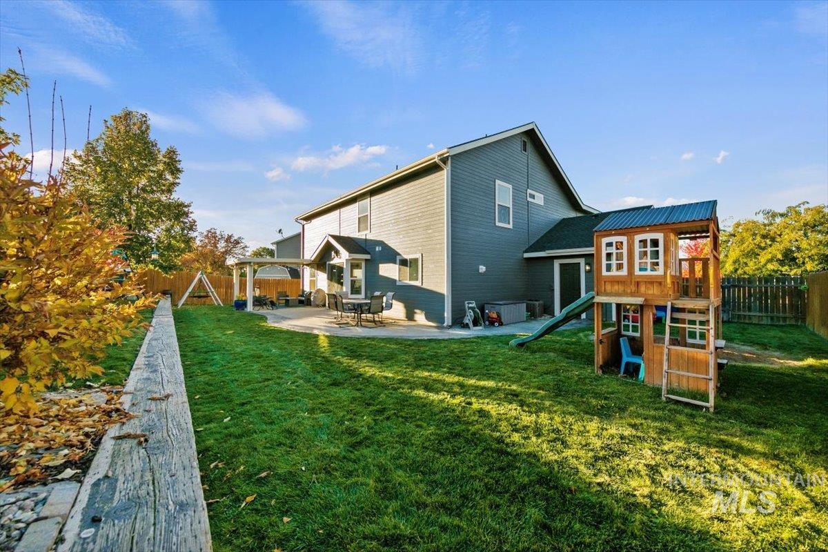 Back of house with a playground, a patio, and a fenced backyard
