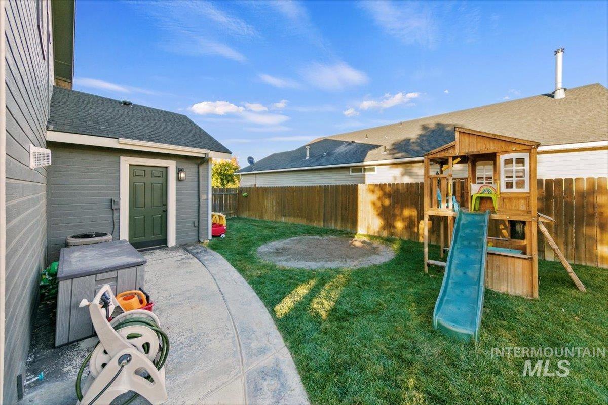 View of playground featuring a fenced backyard and a patio