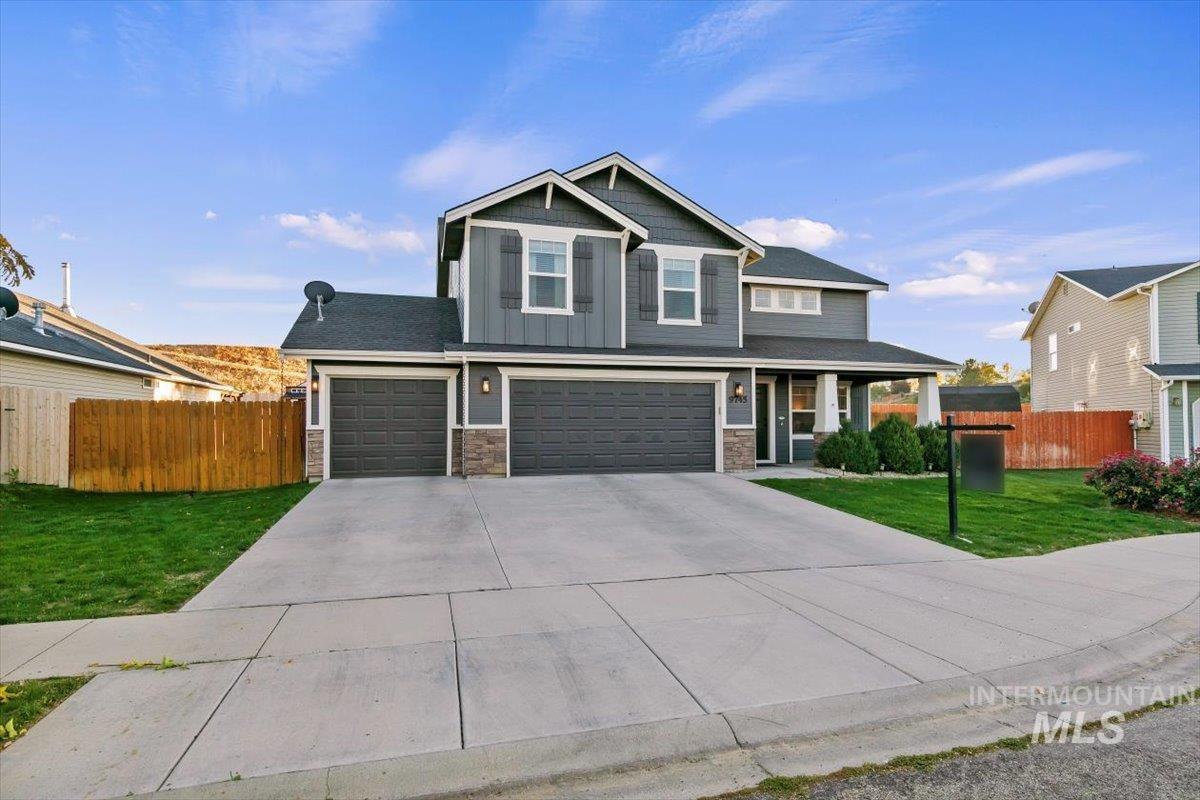 Craftsman house featuring board and batten siding, stone siding, concrete driveway, and a garage