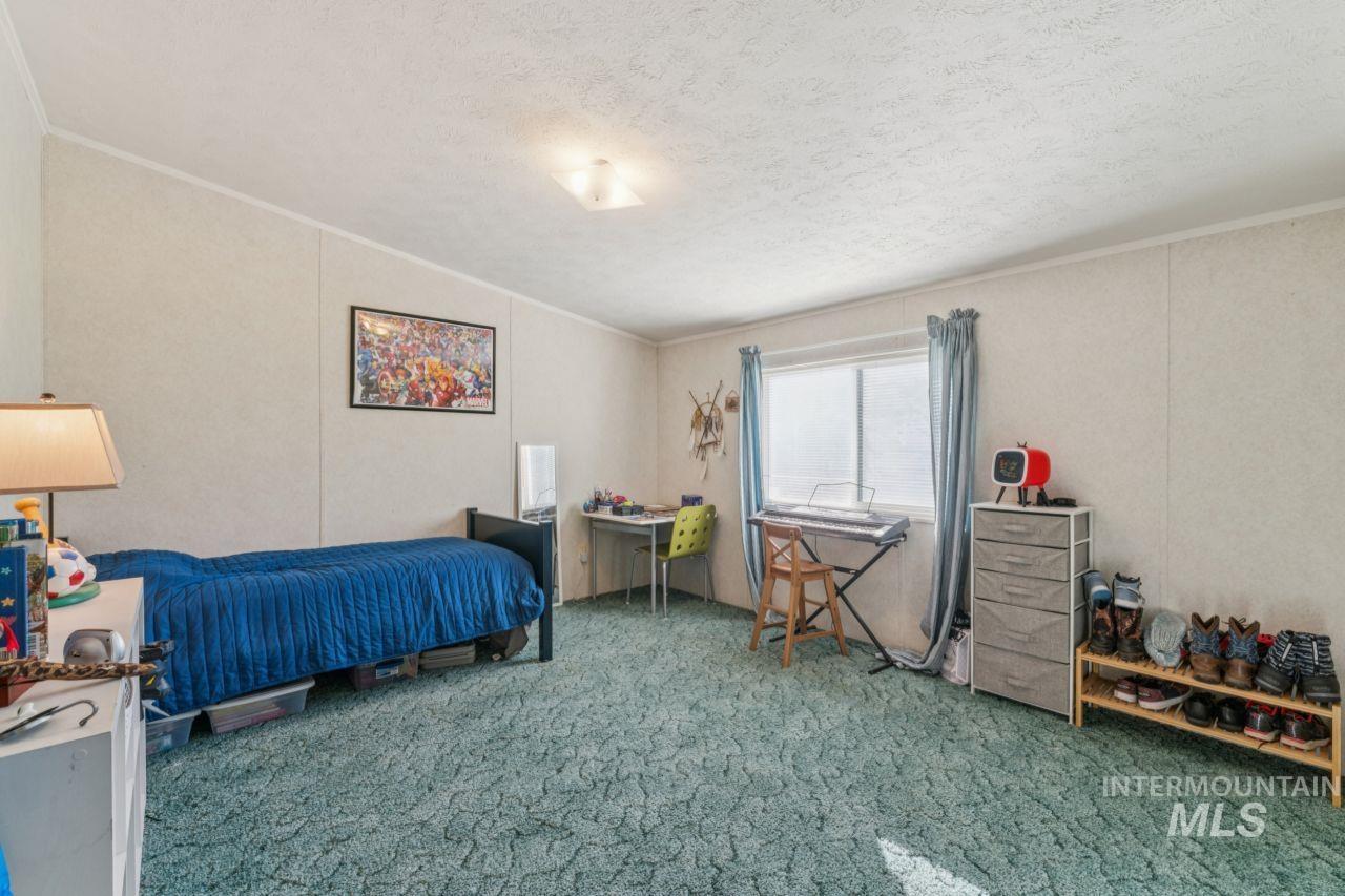 Bedroom with carpet flooring, crown molding, and a textured ceiling