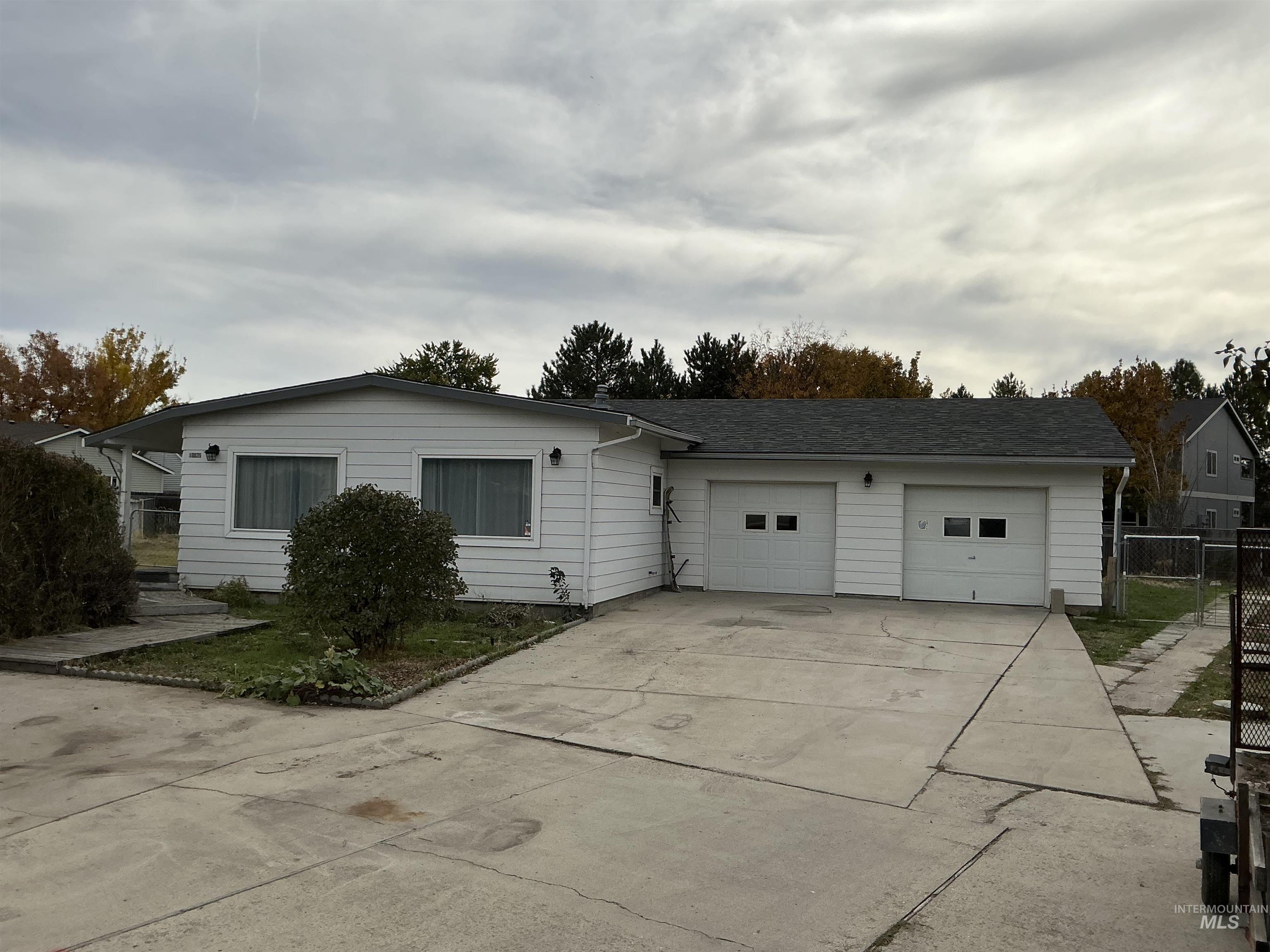 View of front of home with driveway, a gate, and a garage