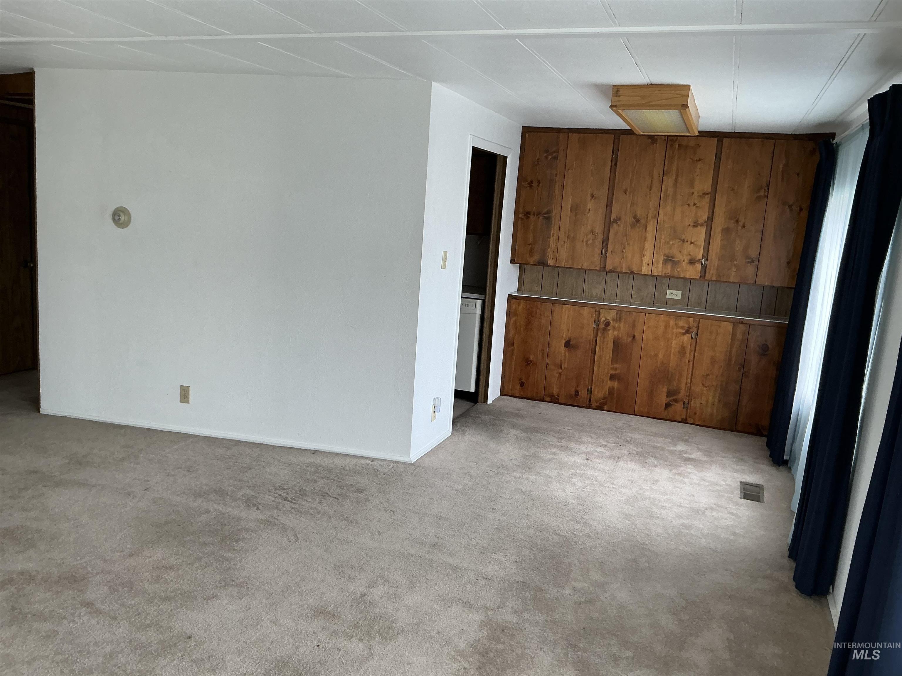 Empty room featuring light colored carpet and baseboards