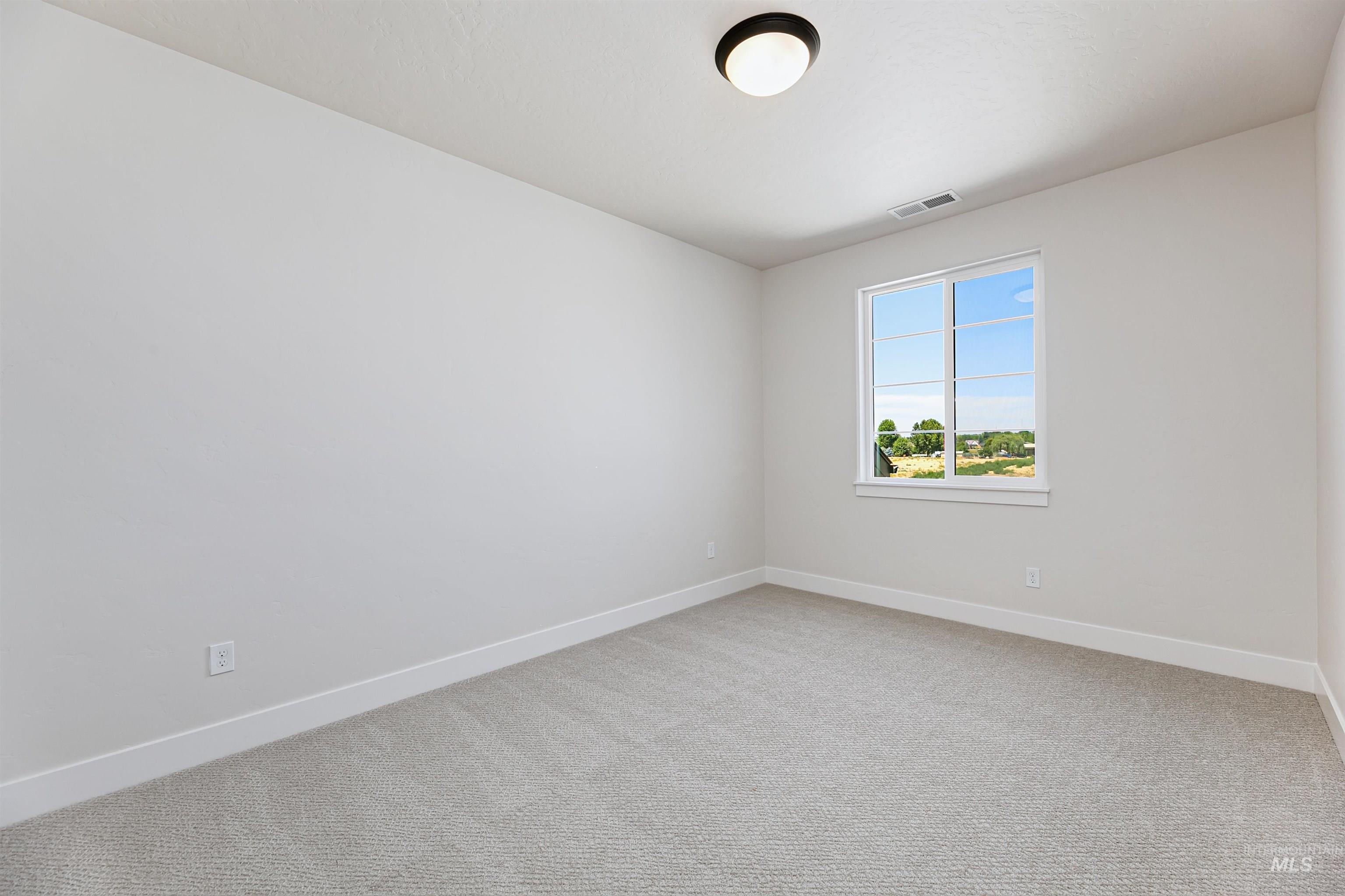 Unfurnished room featuring baseboards and light carpet
