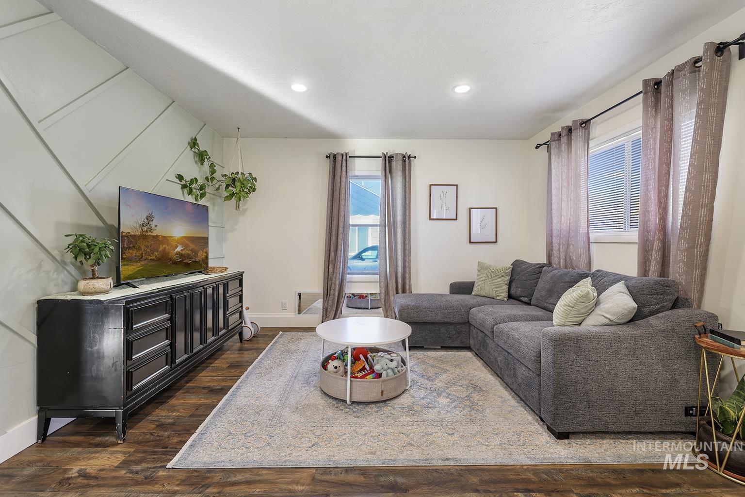 Living area featuring dark wood finished floors and recessed lighting