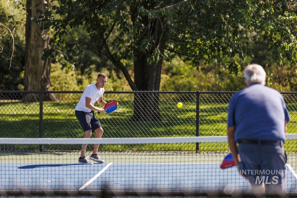 View of tennis court with view of scattered trees