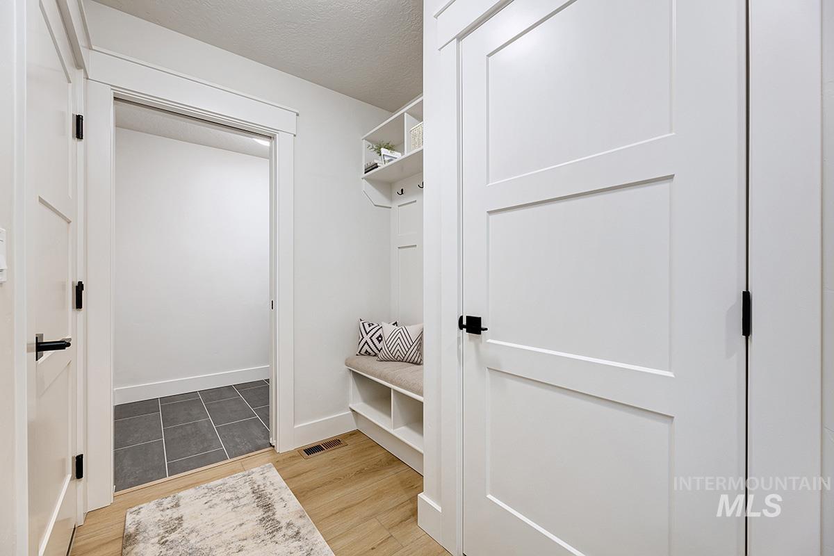 Mudroom featuring a textured ceiling and light wood-style flooring