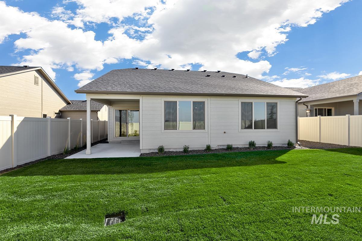 Rear view of house with a patio area, a fenced backyard, and a shingled roof