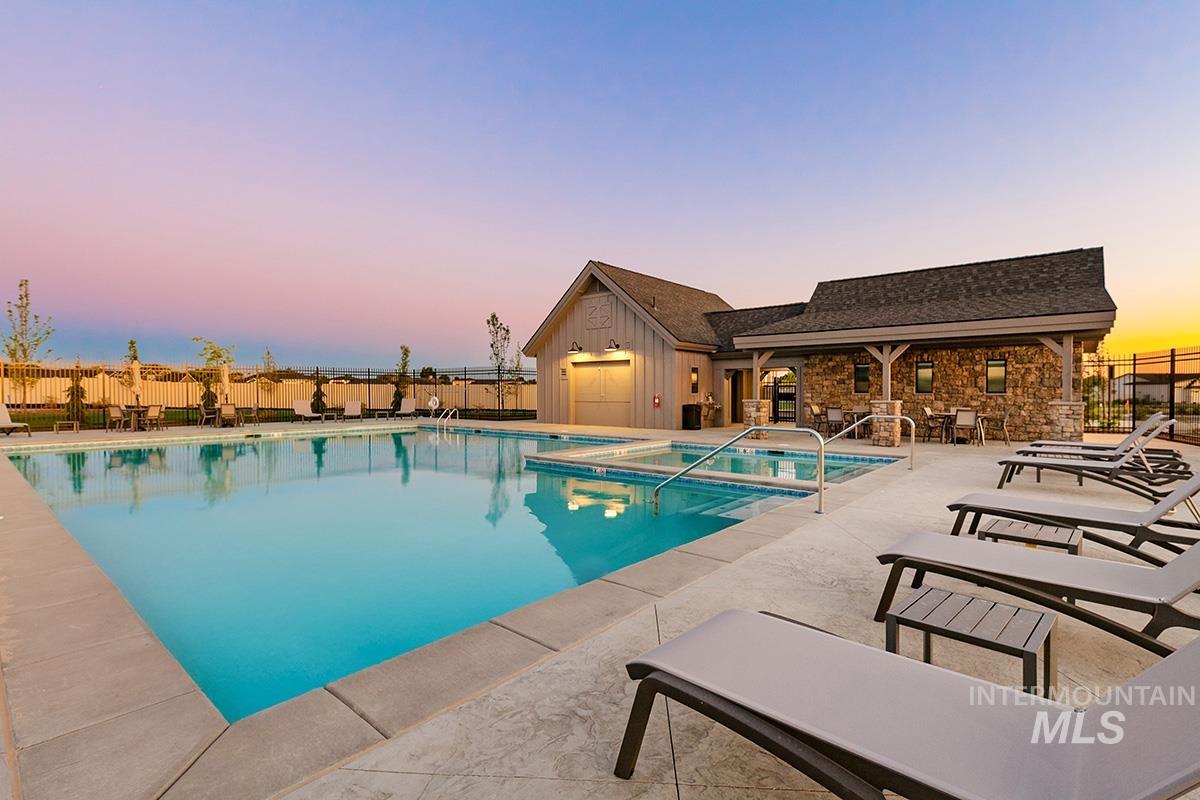 Pool at dusk with a patio and a community pool