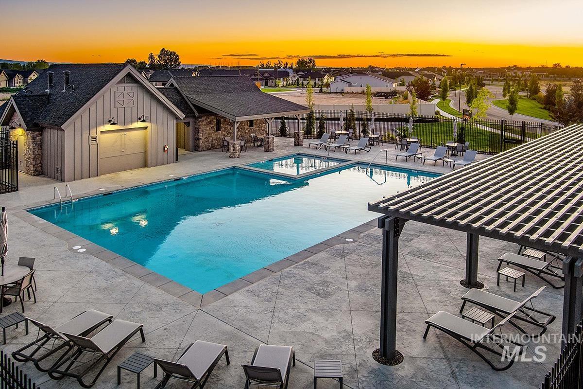 View of pool with a patio area, a pergola, and a pool with connected hot tub