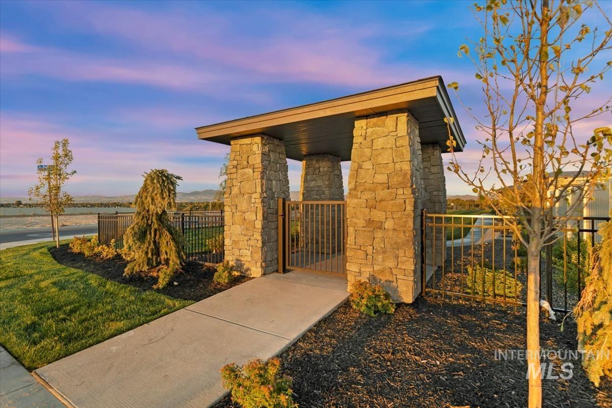 Outdoor structure at dusk with a fenced front yard and a gate