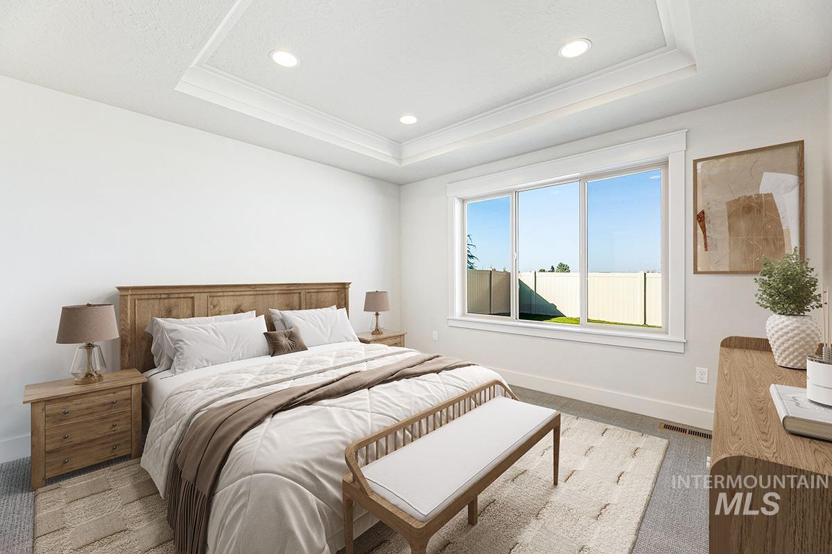 Carpeted bedroom with a raised ceiling, recessed lighting, and ornamental molding