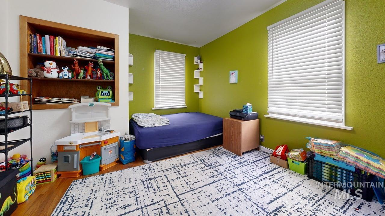 Bedroom with wood finished floors and baseboards