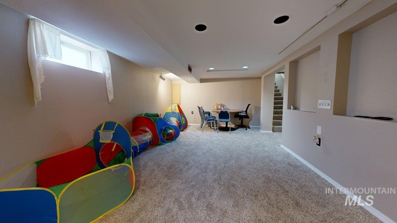 Game room featuring carpet and baseboards