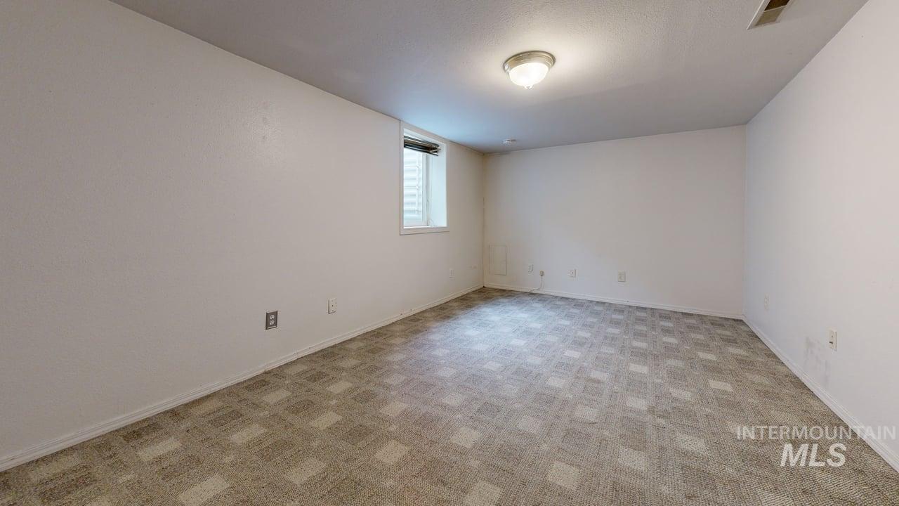 Spare room with light carpet and baseboards