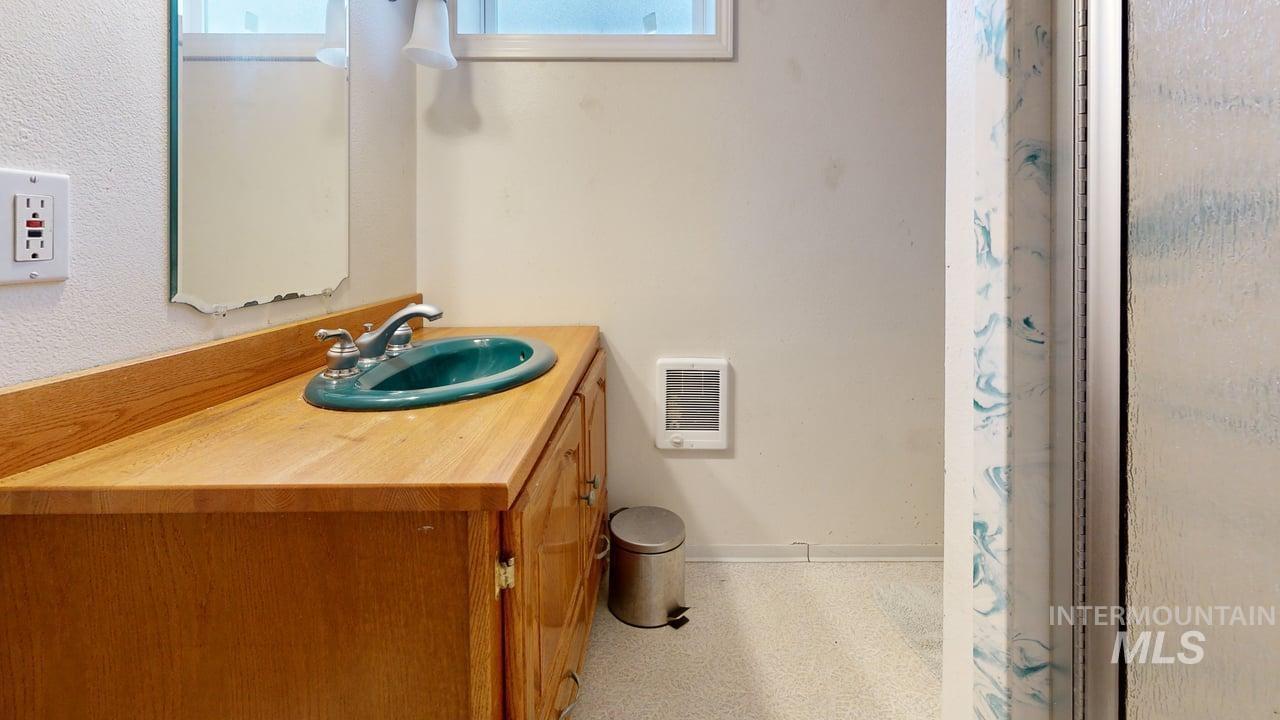 Bathroom with a shower with shower curtain, vanity, and plenty of natural light