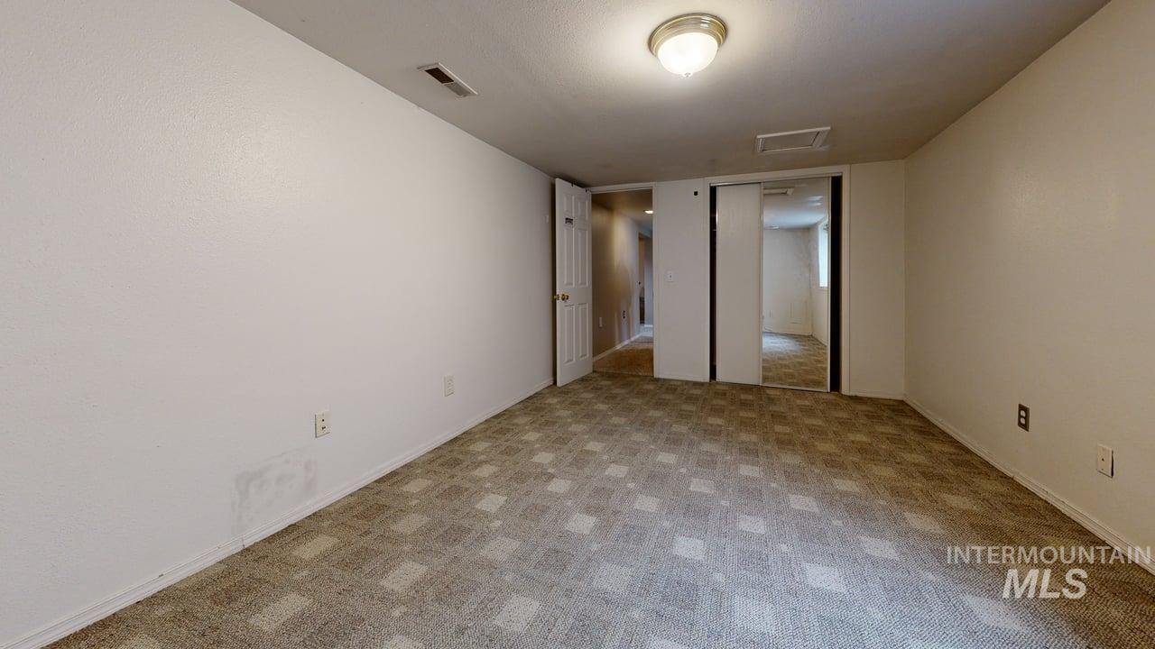 Unfurnished bedroom with carpet flooring and baseboards