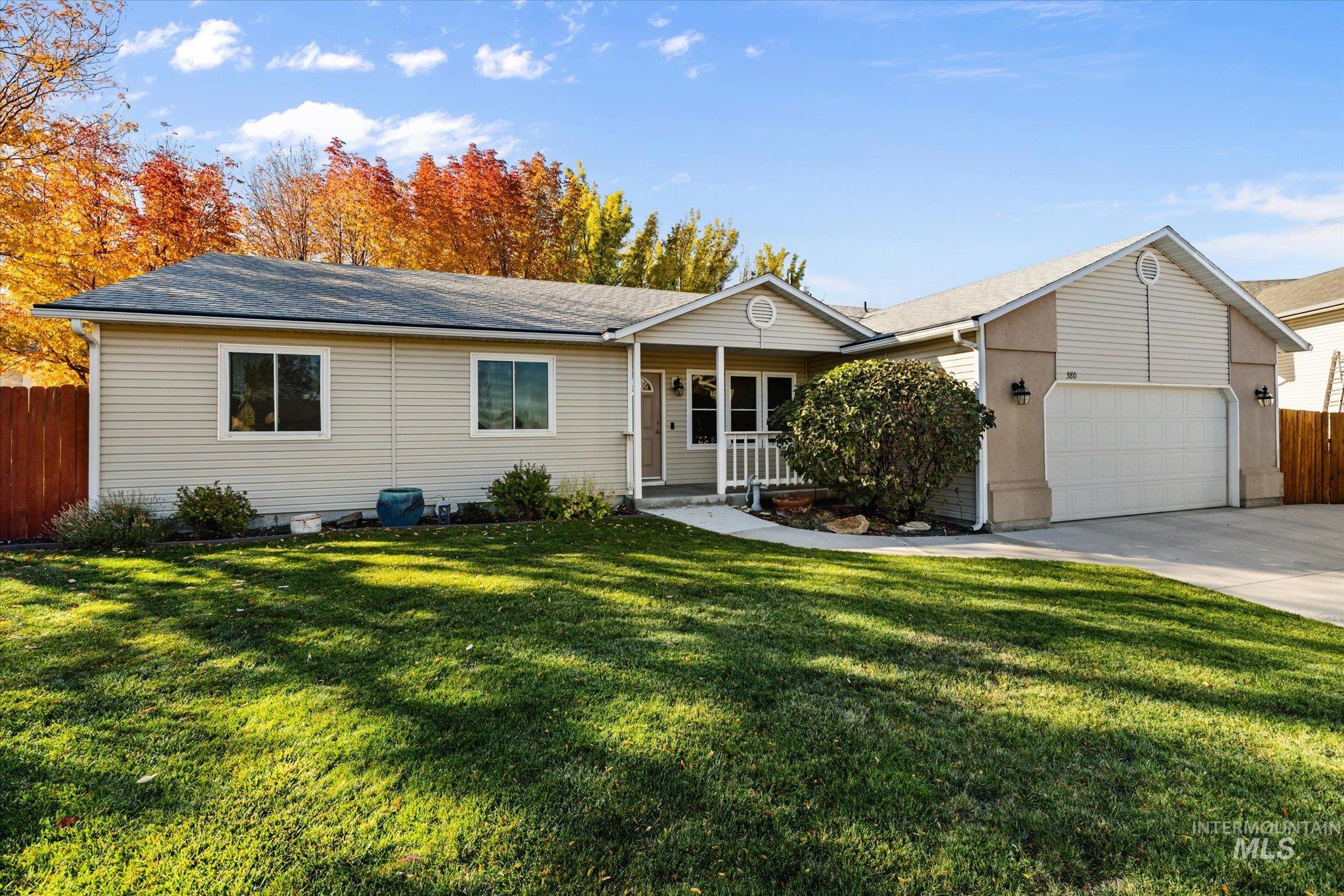 Single story home with a porch, concrete driveway, an attached garage, and a shingled roof