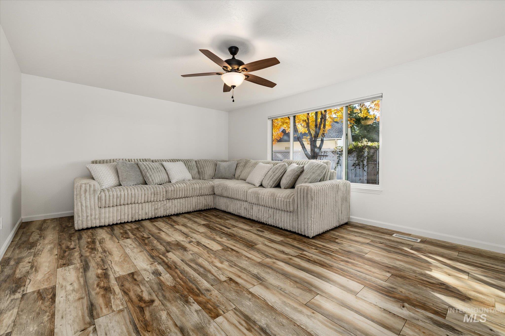 Living room with a ceiling fan and light wood-style floors