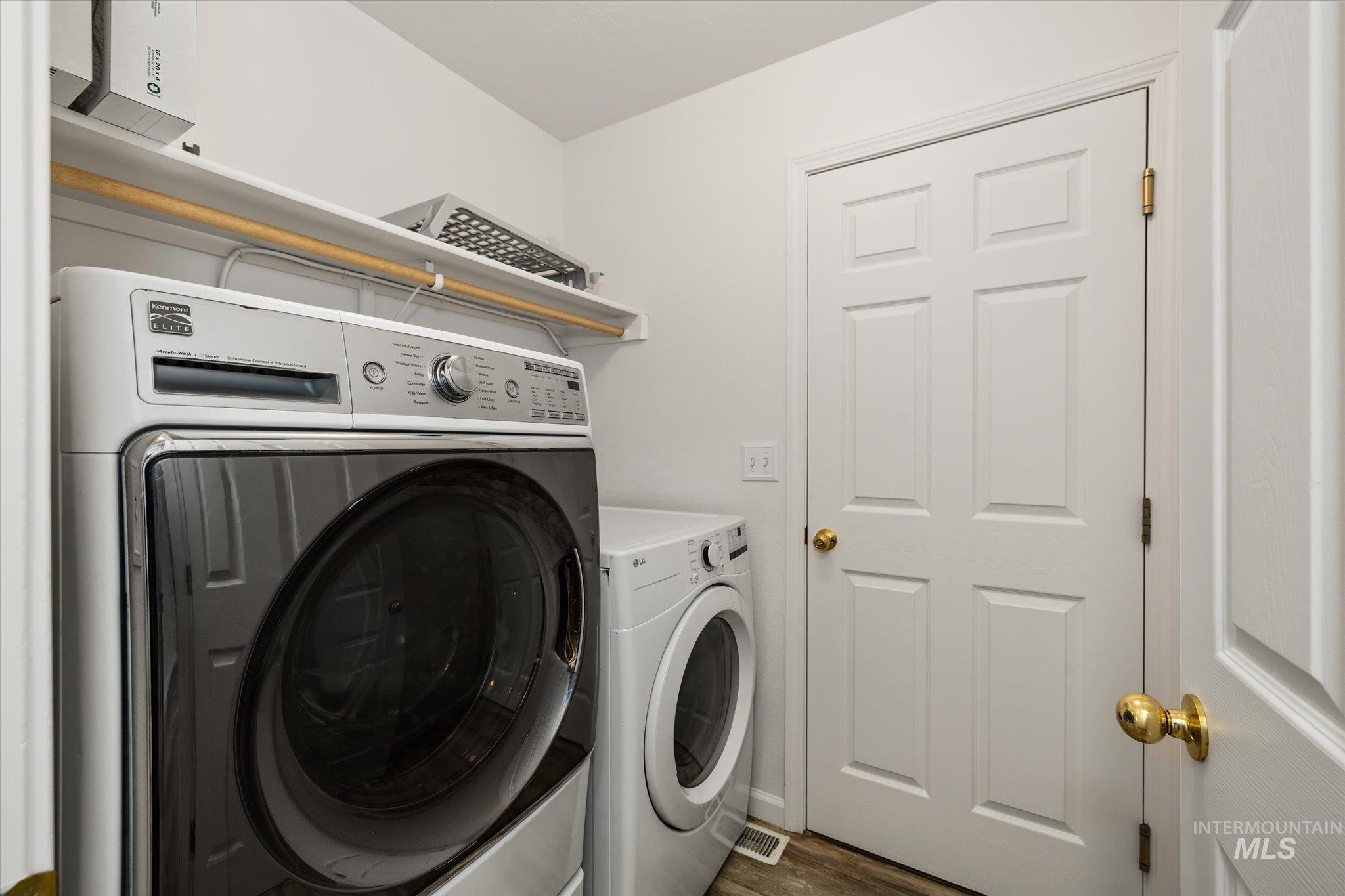 Laundry area with independent washer and dryer and dark wood finished floors