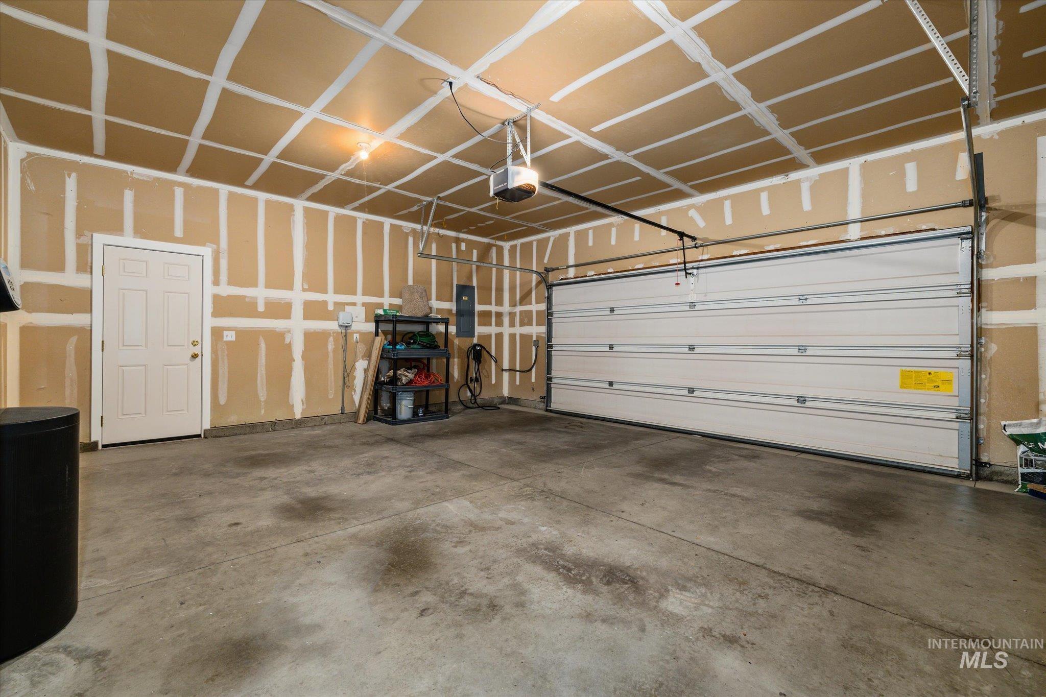 Garage with electric panel and a garage door opener