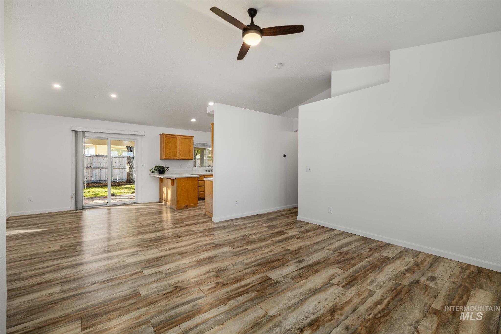 Unfurnished living room with recessed lighting, light wood-style flooring, ceiling fan, and vaulted ceiling