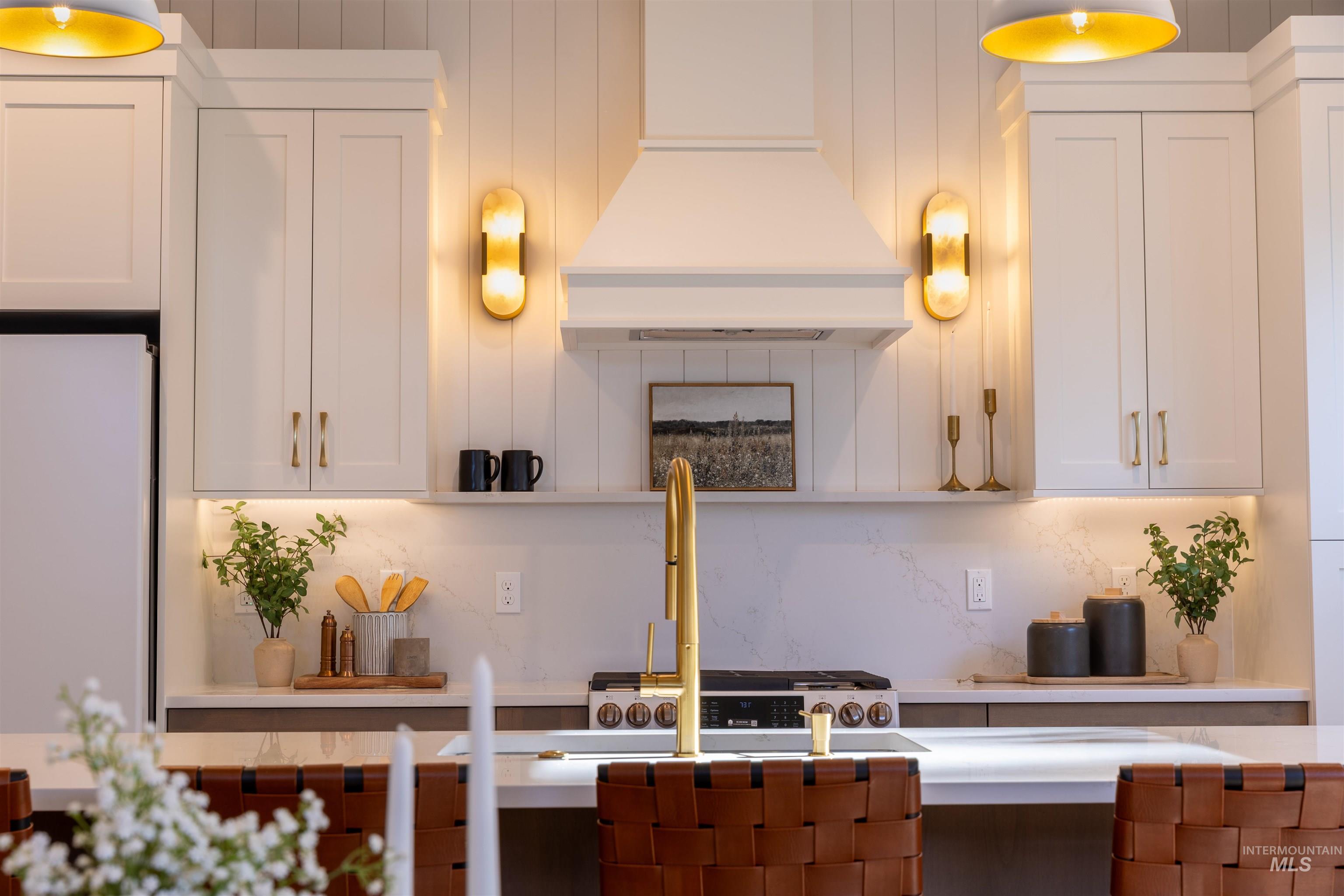 Kitchen with white cabinetry, tasteful backsplash, custom range hood, and freestanding refrigerator