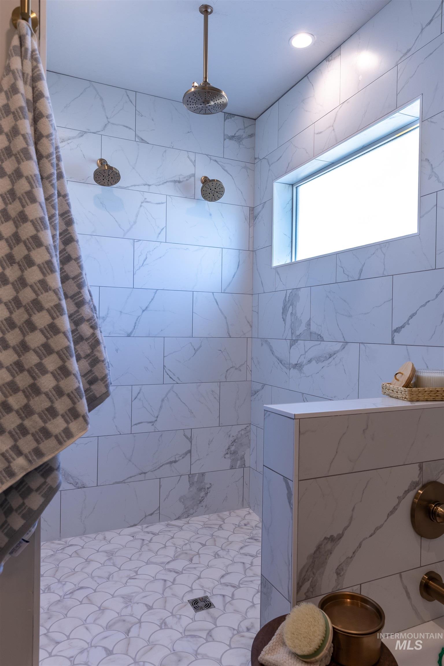 Full bathroom with a tile shower and tile walls