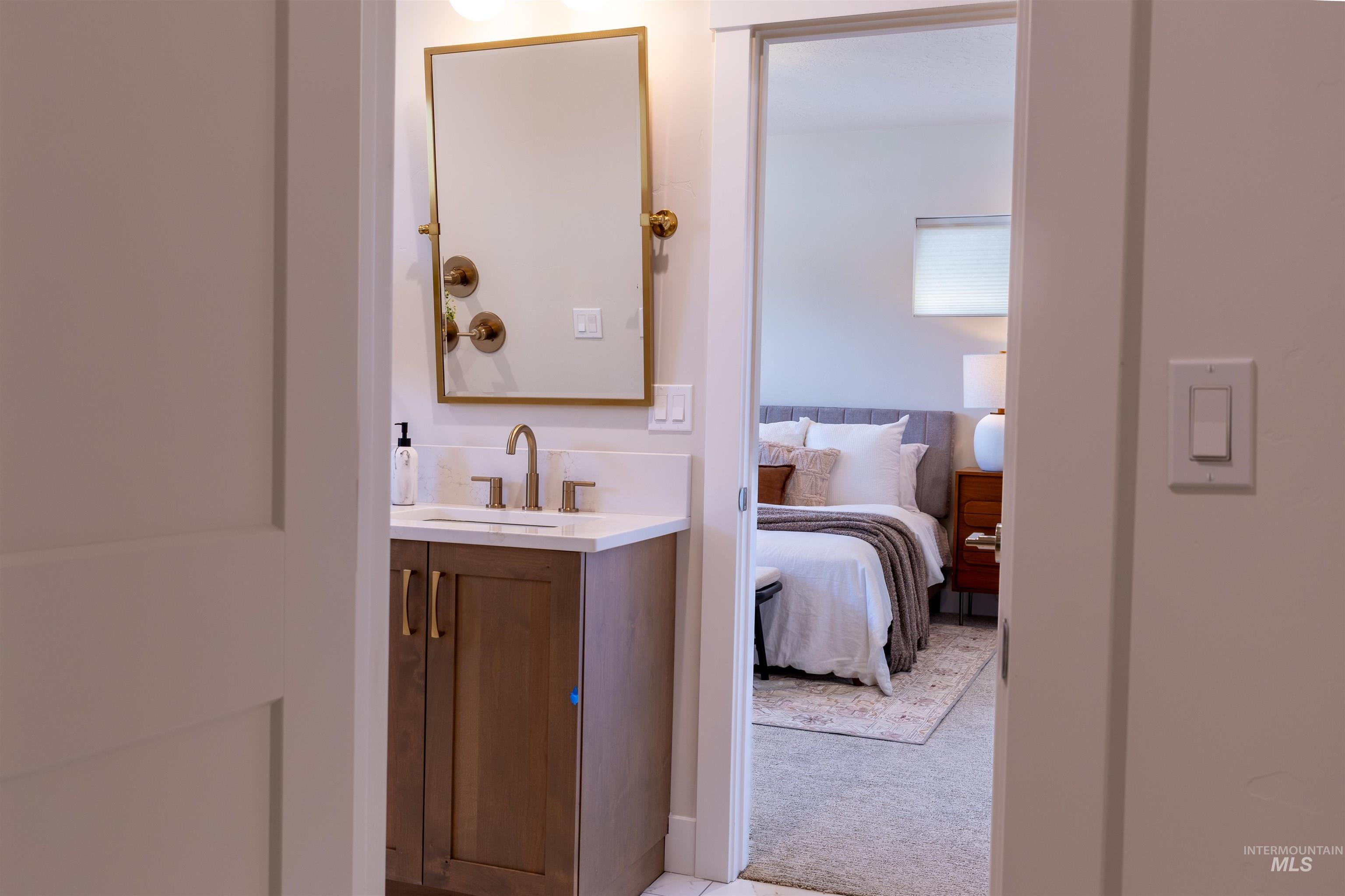 Bathroom with vanity, light colored carpet, and connected bathroom