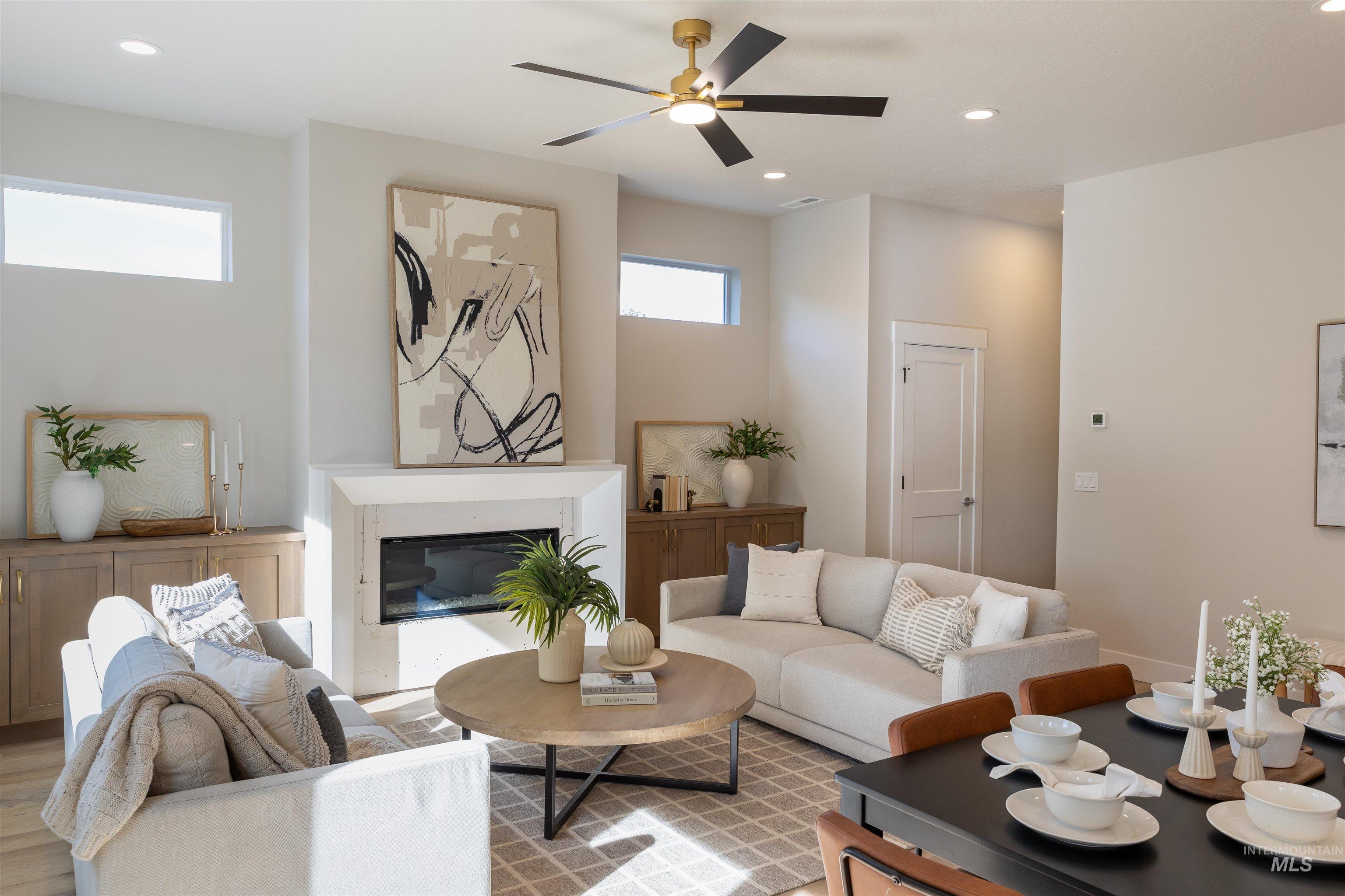 Living area with recessed lighting, a high end fireplace, ceiling fan, and wood finished floors
