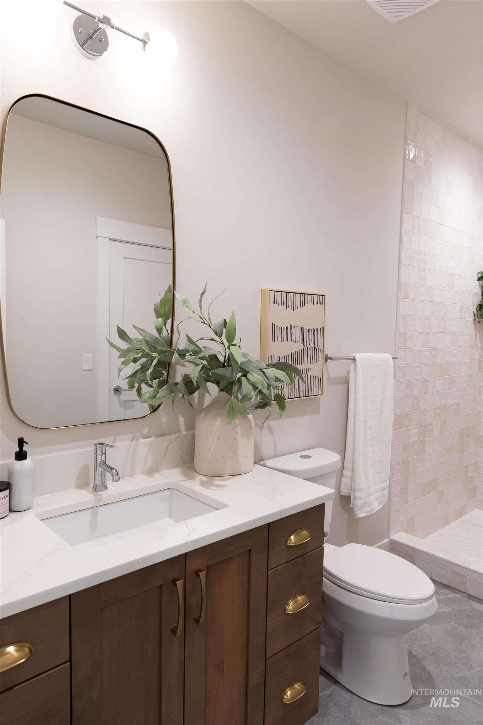 Full bath featuring vanity and a tile shower