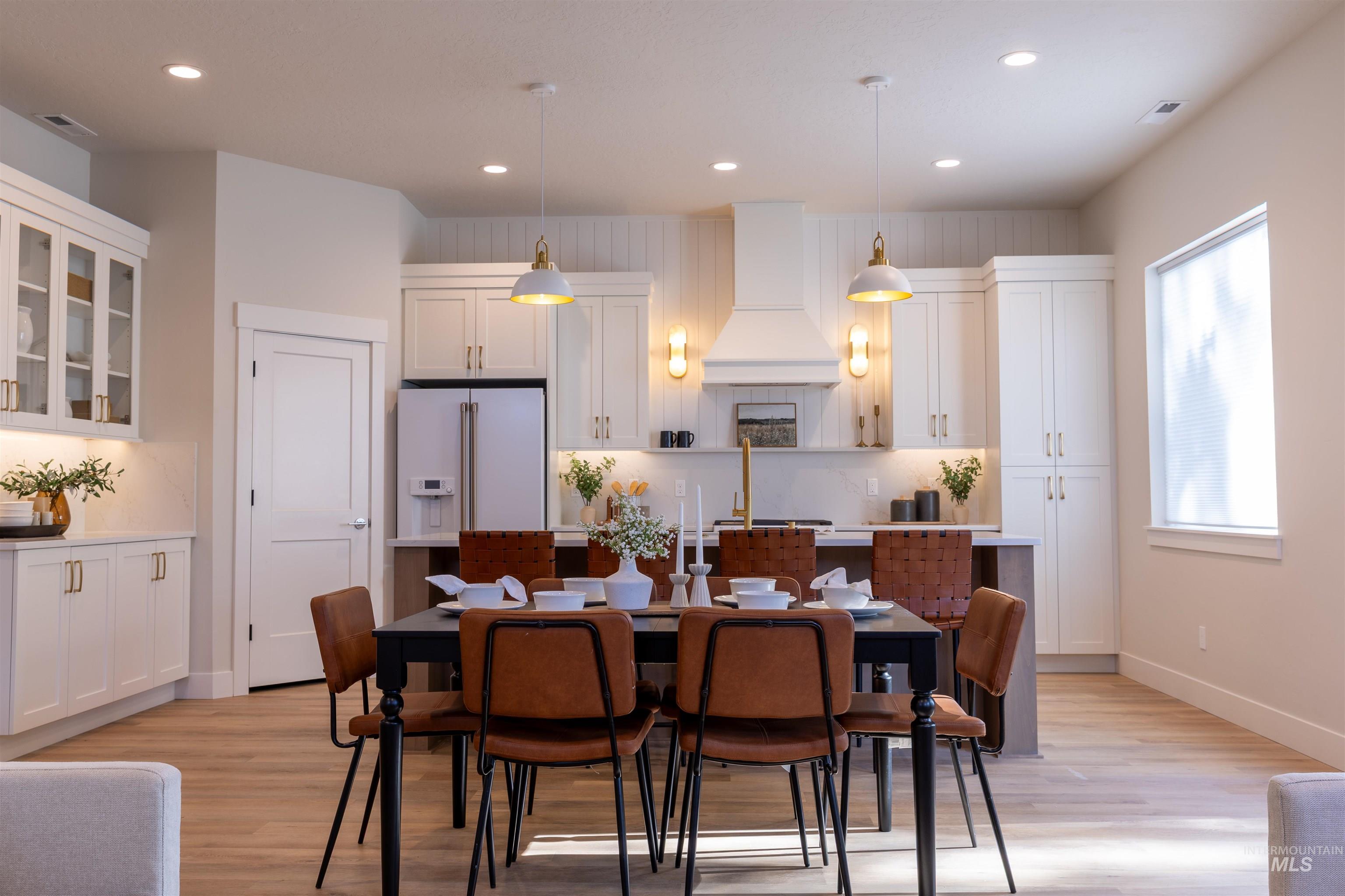 Dining area with recessed lighting and light wood-type flooring