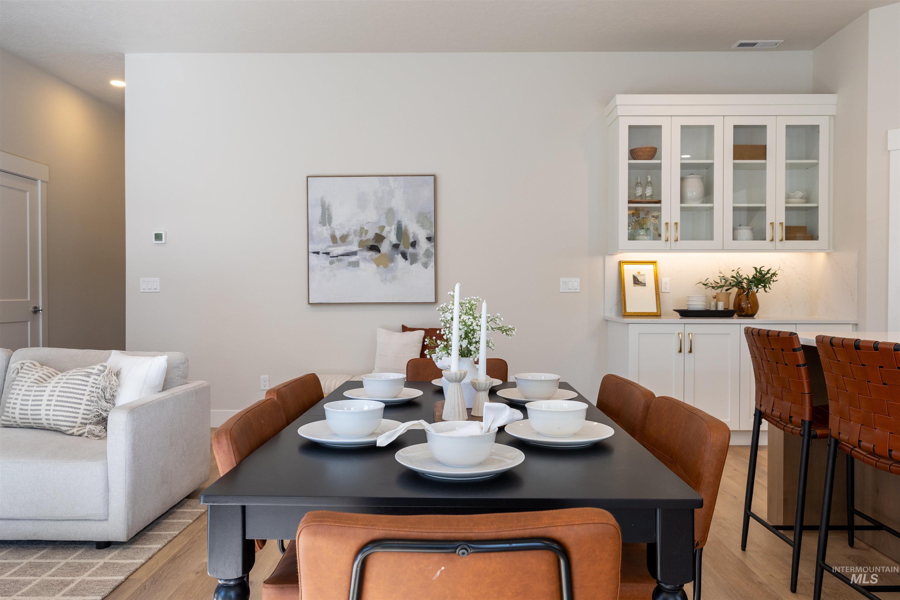 Dining space with light wood finished floors and recessed lighting