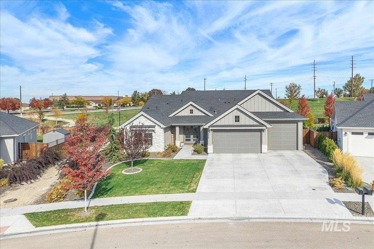 Craftsman inspired home featuring board and batten siding, a garage, and driveway