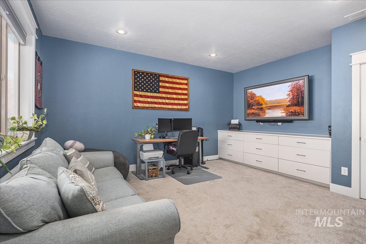 Office area featuring light colored carpet, a textured ceiling, and recessed lighting