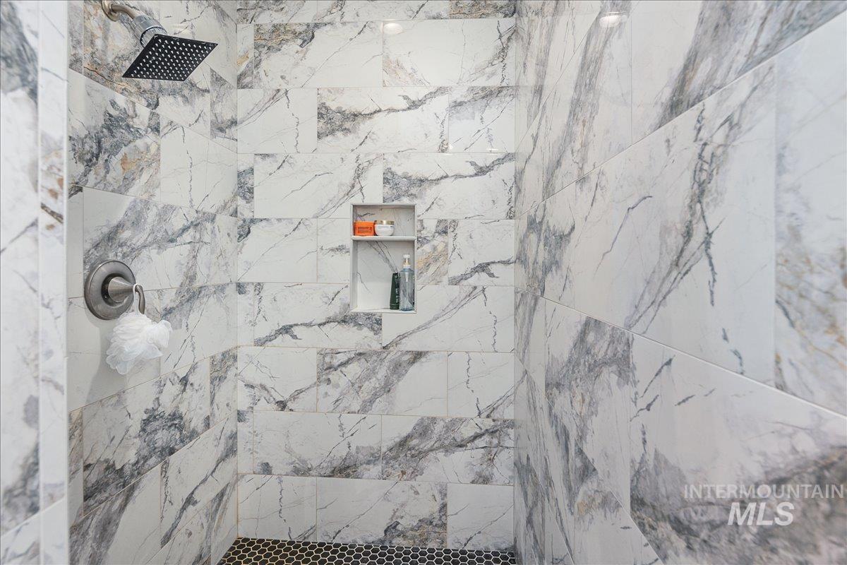 Full bathroom with a marble finish shower