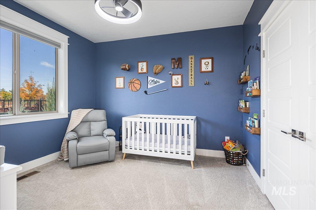 Bedroom with carpet and a crib