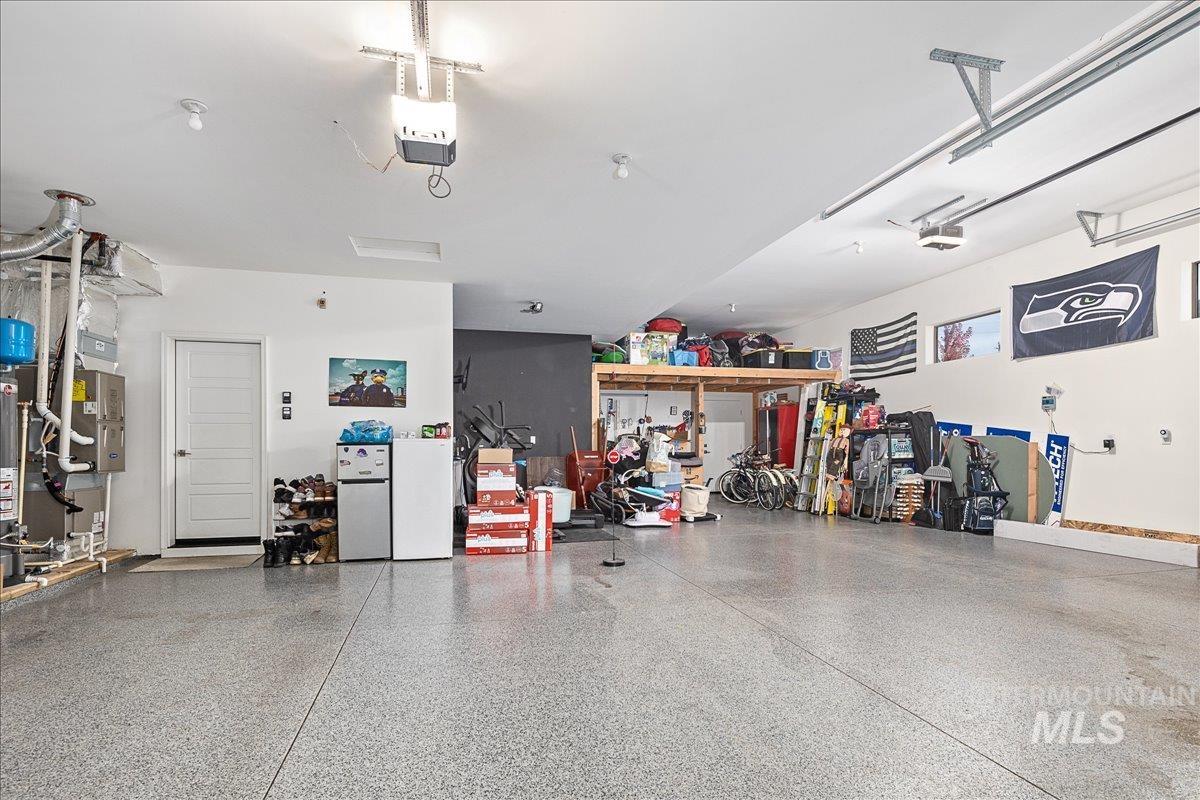 Garage featuring freestanding refrigerator and a garage door opener