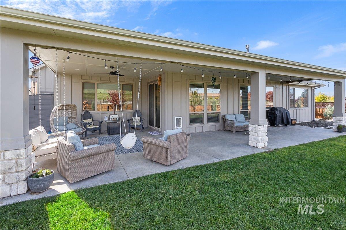 Rear view of house featuring a ceiling fan, outdoor lounge area, a patio, and board and batten siding