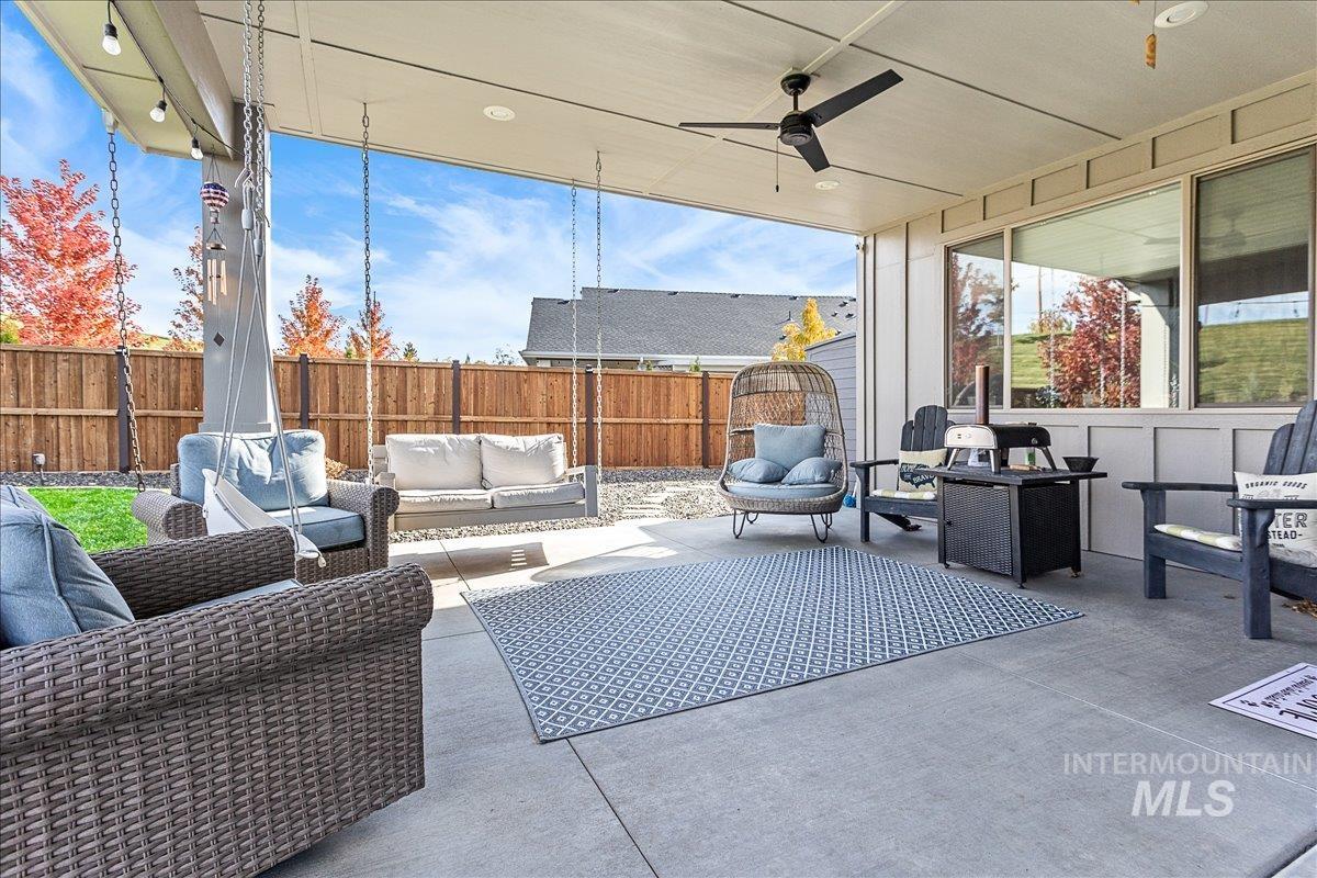 Fenced backyard featuring outdoor lounge area, a ceiling fan, and a patio area