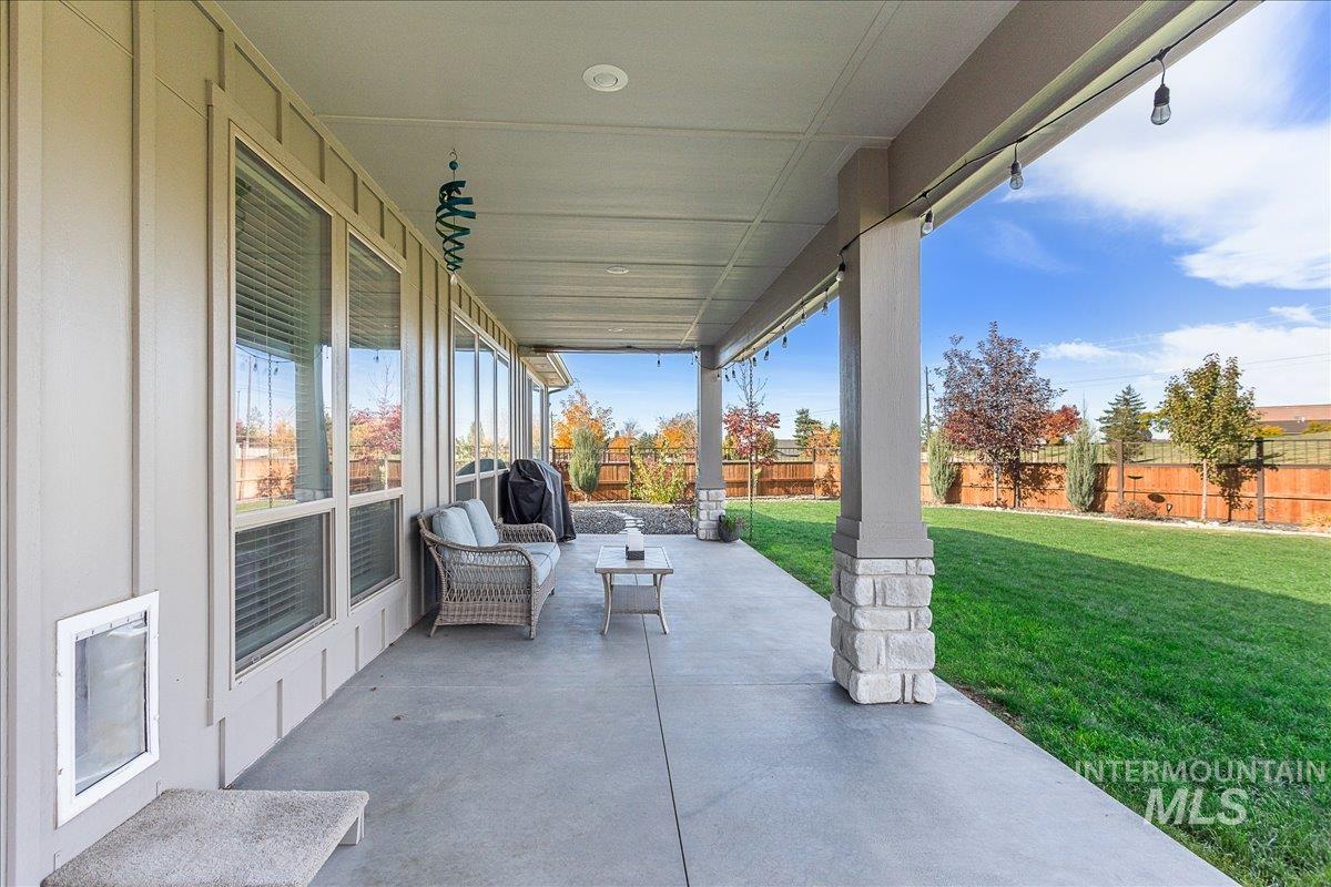 Fenced backyard with a patio and a grill